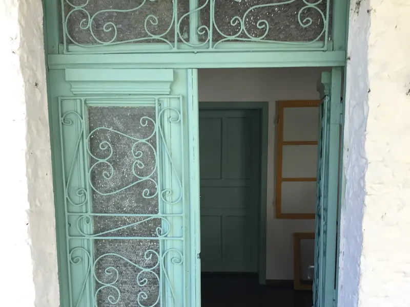 The green front door with wrought-iron details