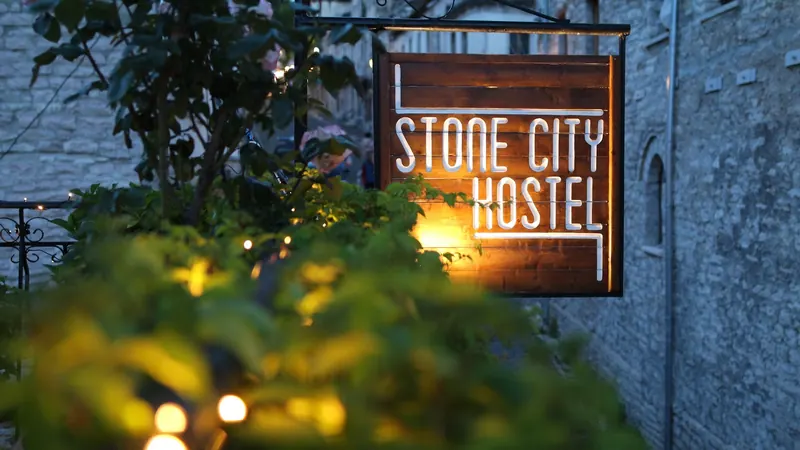 The Stone City Hostel sign glowing at dusk