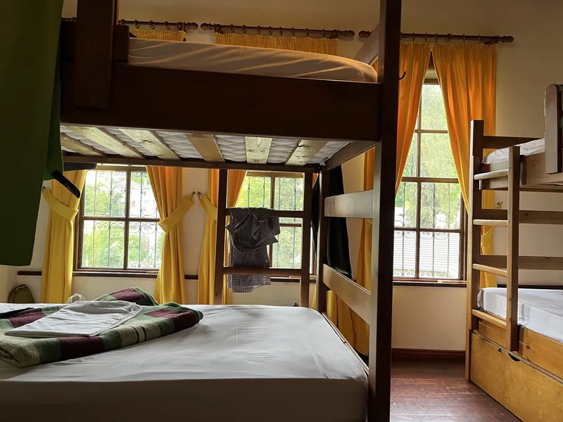 Dorm with wooden bunk beds and yellow curtains