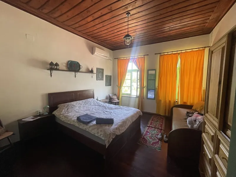 Private room with a wooden ceiling, double bed and kilim rug